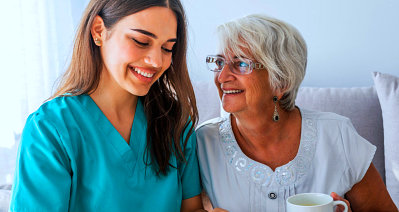 caregiver and senior woman wearing eyeglasses smiling