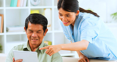 caregiver assisting senior woman on the tablet